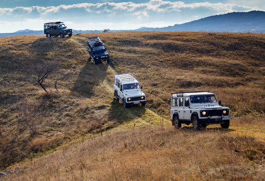 Land Rovers driving down a track