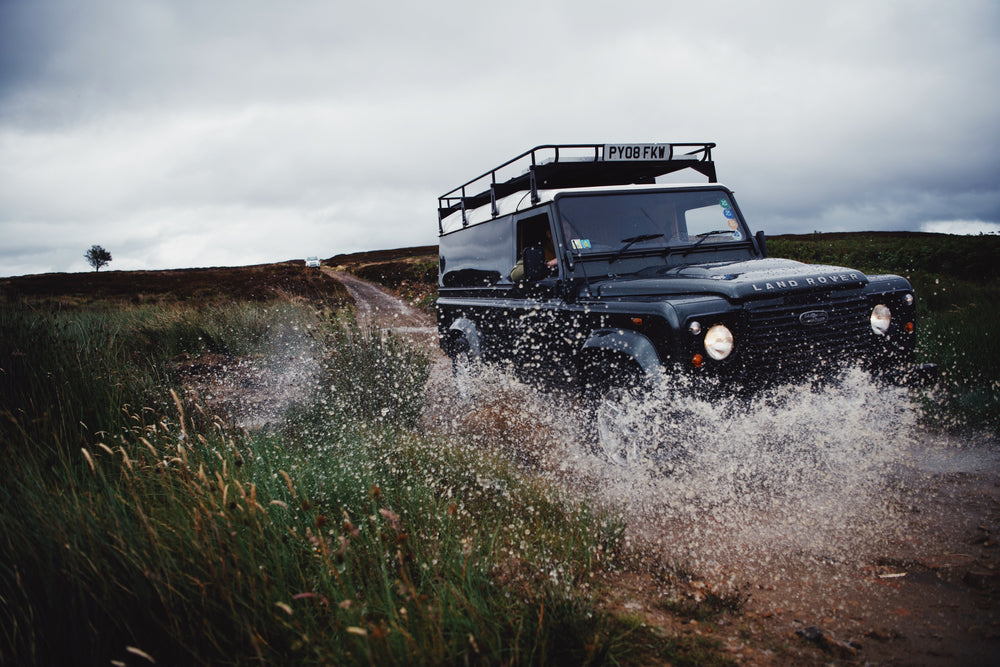 Land Rover splashing through a puddle.