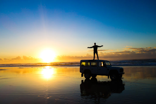 Land Rover Defender on a beach in the sunset